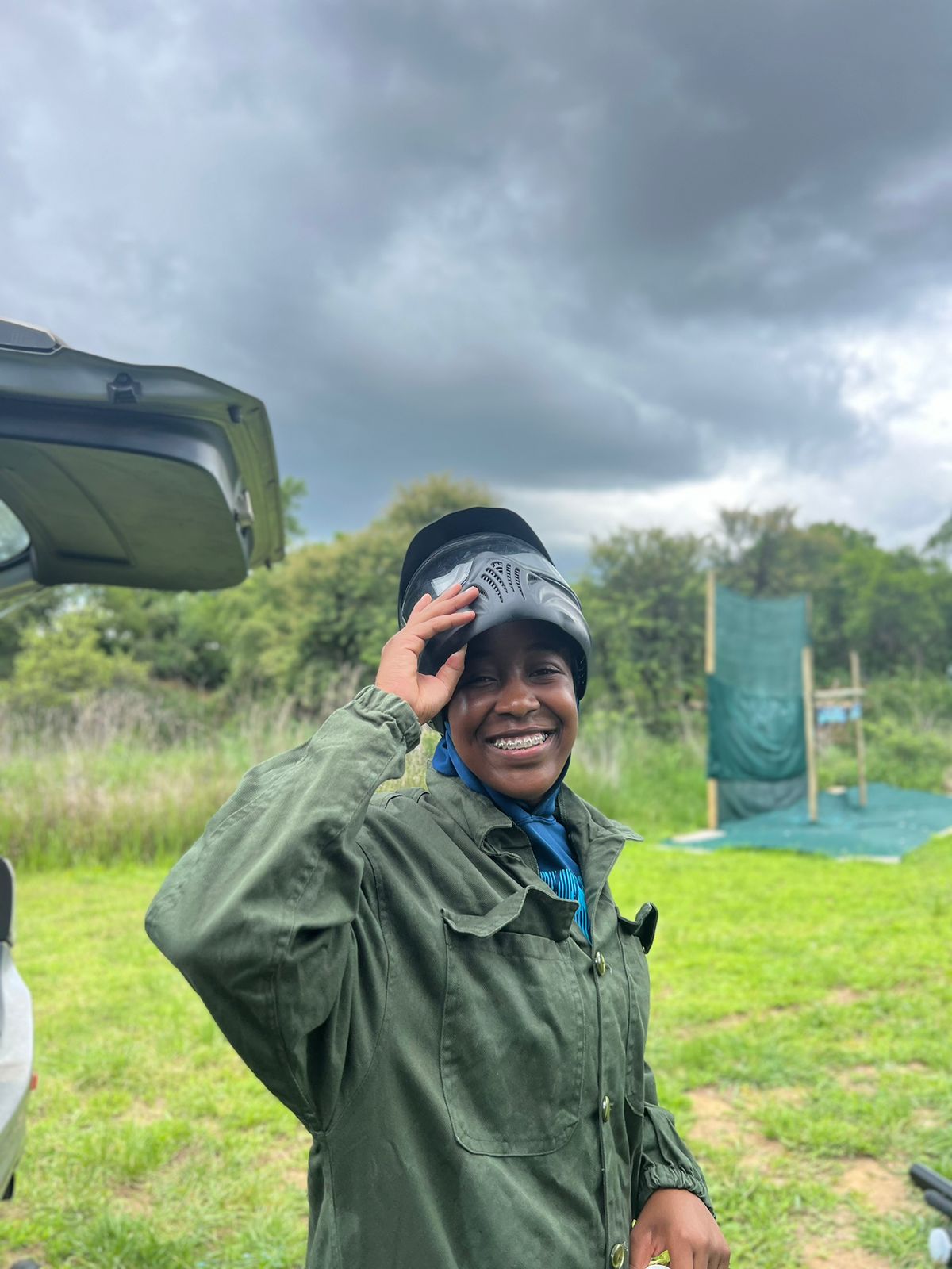 smiling participant in paintball gear ready for game