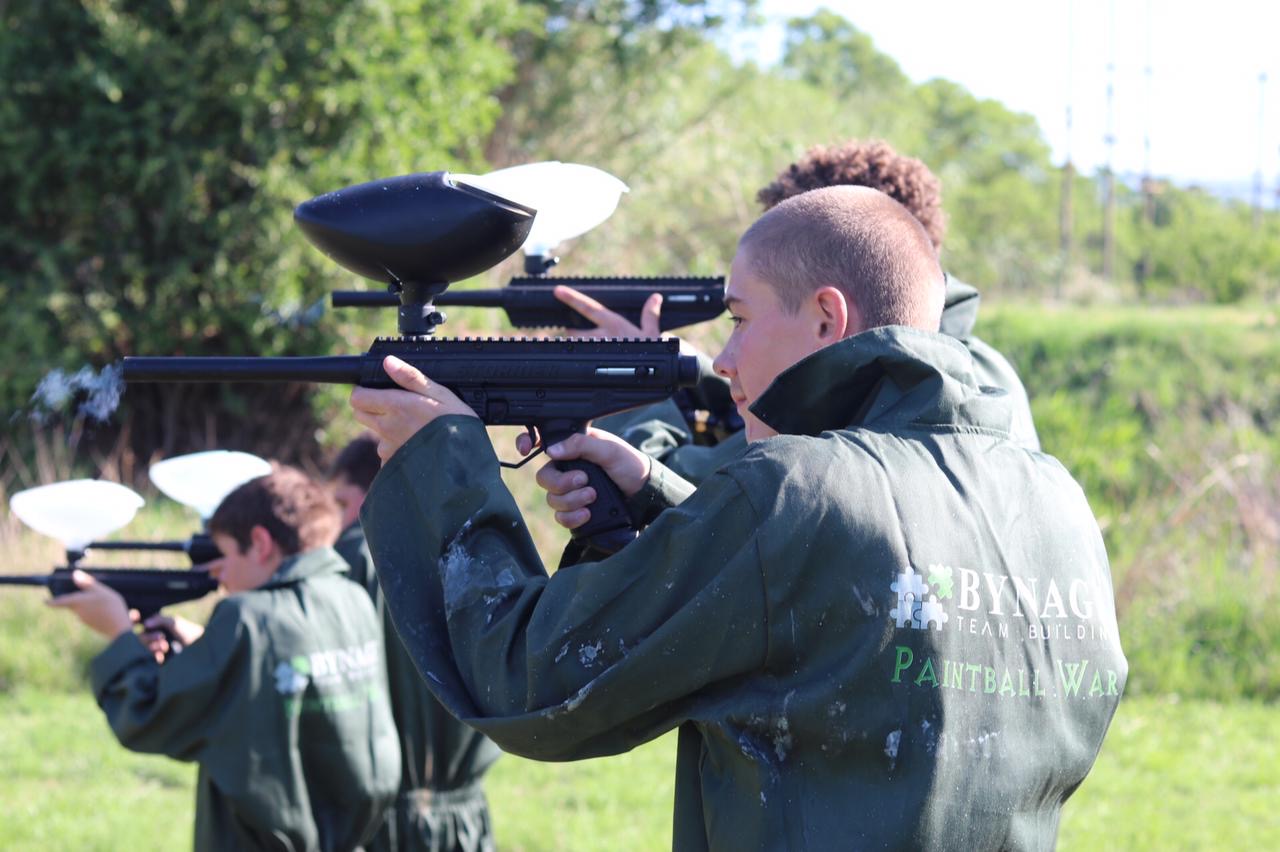 player aiming paintball gun during outdoor game