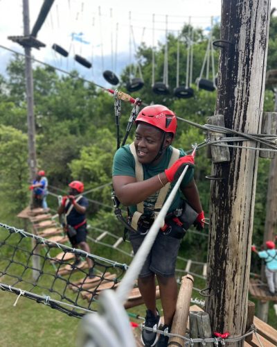 team crossing rope bridge obstacle course